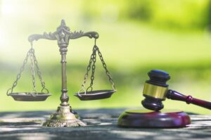 英文契約書と日本語契約書の法体系の違いを象徴する天秤とガベル